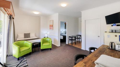 a living room with a table and a green chair at Best Western Caboolture Gateway Motel in Caboolture