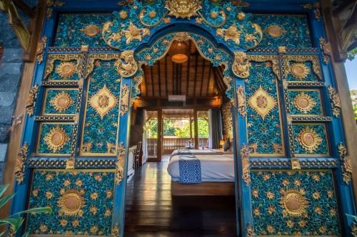 Un dormitorio con una pared azul y dorada. en Parvati Retreat Villas, en Ubud
