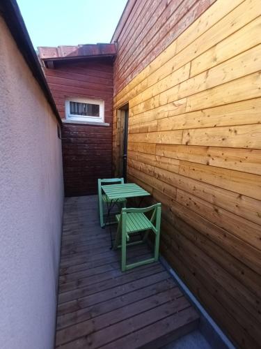 un mur en bois avec une table et des bancs sur une terrasse dans l'établissement Petite maison atypique, à Saint-Rémy-en-Bouzemont-Saint-Genest-et-Isson