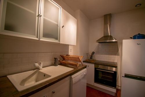 a kitchen with a sink and a refrigerator at Nouveau ! T2 lumineux en centre ville in Aix-en-Provence