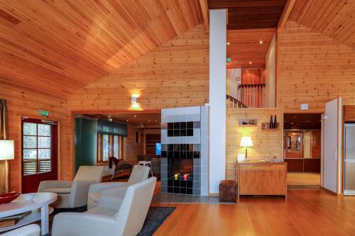 a living room with white furniture and a fireplace at KätkänKiisa in Kittilä
