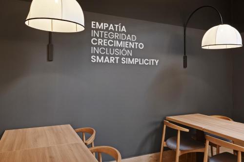a dining room with two tables and two lights at B&B HOTEL Málaga Centro in Málaga