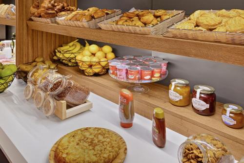 a buffet with bread and other food items on a table at B&B HOTEL Málaga Centro in Málaga
