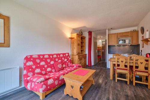 un salon avec un canapé rouge et une table dans l'établissement La montagne, à Les Deux Alpes