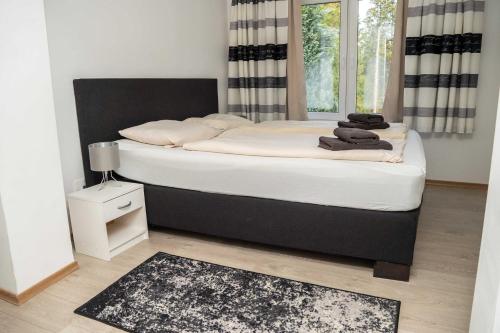 Un dormitorio con una cama grande con sábanas blancas. en Villa Nordhang - Apartment 4, en Winterberg