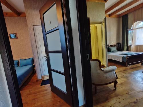 a room with a bed and a mirror and a chair at Golden Gate in Akhaltsikhe