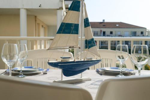 - un petit voilier sur une table avec des verres à vin dans l'établissement Appartement dans résidence de vacances, avec piscine, quartier Pironniere Les Sables 4 personnes, à Les Sables-dʼOlonne