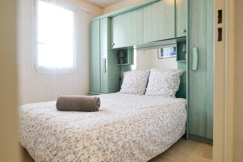 ein Schlafzimmer mit einem großen Bett mit einem braunen Kissen darauf in der Unterkunft Appartement dans résidence de vacances, avec piscine, quartier Pironniere Les Sables 4 personnes in La Pironnière