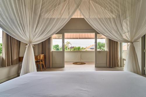 克罗柏坎villa Chamia 2 chambres - proche Umalas的一间卧室配有床和窗帘