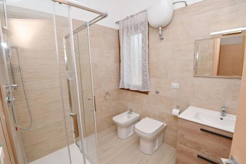 a bathroom with a shower and a toilet and a sink at Villa della Monica Pure relax in Camisa