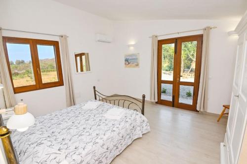 a white bedroom with a bed and a window at Villa della Monica Pure relax in Camisa