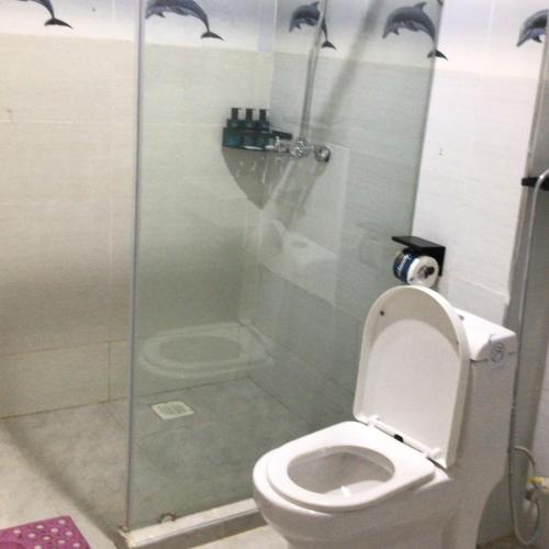 a bathroom with a toilet and a glass shower at Key Villa in Homa Bay