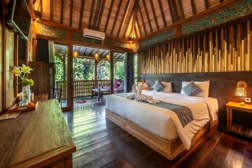 Un dormitorio con una cama grande en una habitación. en Parvati Retreat Villas, en Ubud
