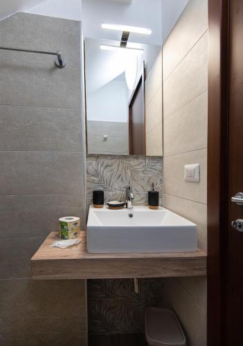 a bathroom with a white sink and a mirror at Nella mia città in Lagonegro