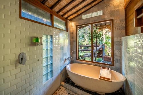 a bath tub in a bathroom with a window at Parvati Retreat Villas in Ubud