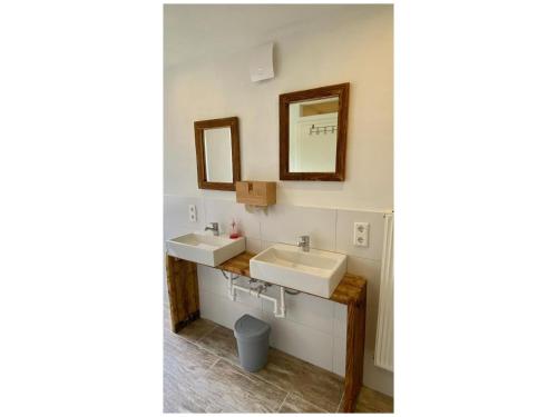 a bathroom with two sinks and two mirrors at Alte Mühle Börfink in Börfink