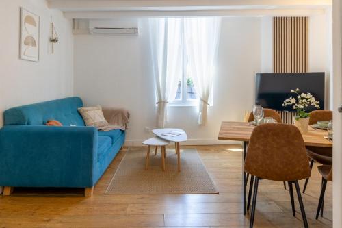 un salon avec un canapé bleu et une table dans l'établissement Le Relax - Maison climatisée avec terrasse - Troyes, à Troyes