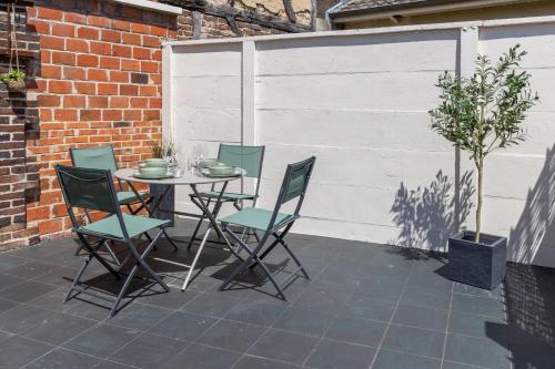 une table et des chaises assises sur une terrasse dans l'établissement Le Relax - Maison climatisée avec terrasse - Troyes, à Troyes
