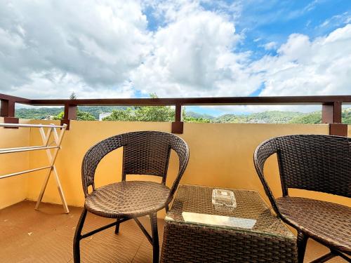 two chairs and a table on a balcony at patong v hotel in Patong Beach