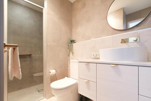 a bathroom with a toilet and a mirror at Glorious 2-Bed with Waterside Balcony Views in Batemans Bay