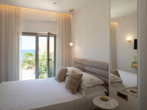 a bedroom with a bed with a view of the ocean at Golden Luxury Suites in Balíon