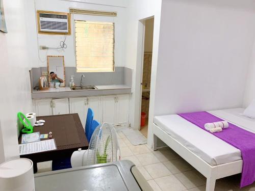 a small room with a bed and a sink at La Pearla Place Boracay Dmall in Boracay