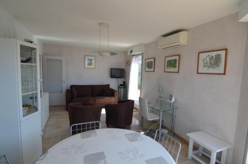 un salon avec une table et un canapé dans l'établissement HELIANTHE - Superbe appartement avec terrasse vue mer et Château au Port de Nice, à Nice