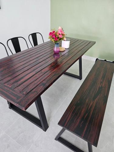 a wooden table with a vase of flowers on it at 34house in Betong