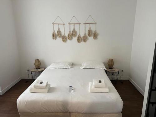 une chambre avec un grand lit blanc avec deux tables dans l'établissement Appartement magnifique paris 18, à Paris