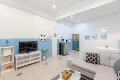 a living room with a couch and a tv at Trisisters Home, near Leegarden in Hat Yai