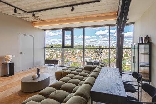 a living room with a couch and large windows at HOUSE38 Panoramic View Apartments SELF CHECK-IN in Kaunas