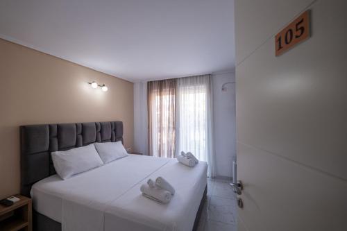 a bedroom with a white bed with two towels on it at Hotel Elite Sarande in Sarandë
