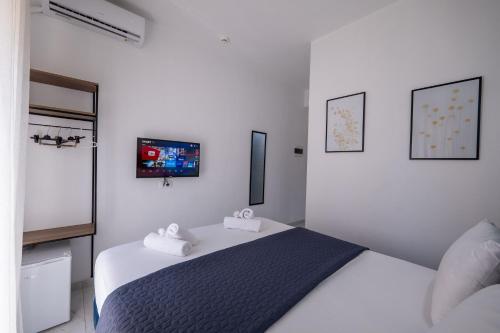 a bedroom with a bed with a tv on the wall at Hotel Elite Sarande in Sarandë