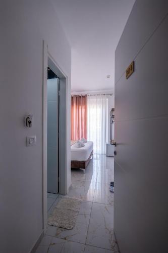 a room with a bedroom with a bed and a door at Hotel Elite Sarande in Sarandë