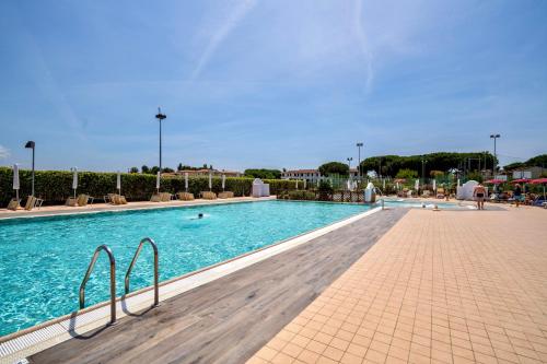 a swimming pool in a resort with people in it at ISA-Residence with swimming pool in Mazzanta at only 600 meters from the beach, apartments with air conditioning and private outdoor area in Mazzanta