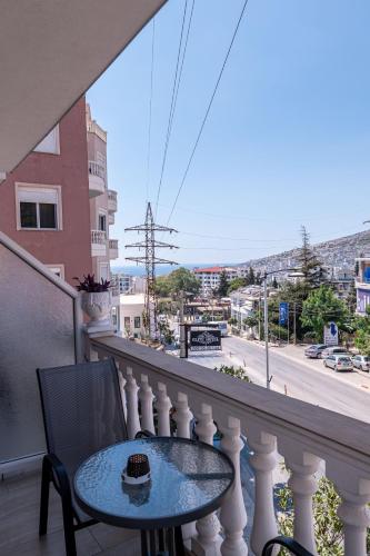 a table and chairs on a balcony with a view of a city at Hotel Elite Sarande in Sarandë
