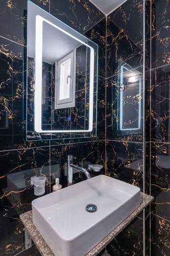 a bathroom with a white sink and a mirror at Hotel Elite Sarande in Sarandë