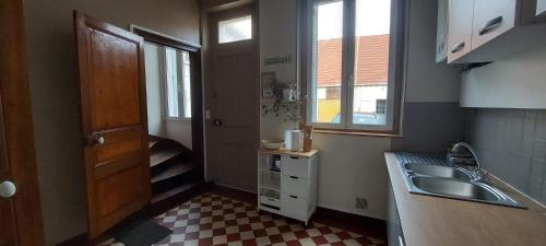 une petite cuisine avec un évier et une fenêtre dans l'établissement L'escapade Féroise, à Fère-en-Tardenois
