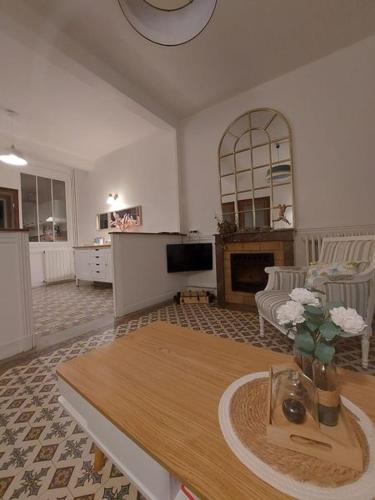 un salon avec une table et une cheminée dans l'établissement L'escapade Féroise, à Fère-en-Tardenois