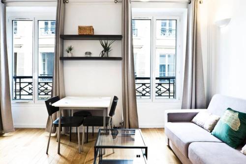 un salon avec un canapé et une table dans l'établissement Bluestay 274 - Charmant Appartement à Paris, à Paris