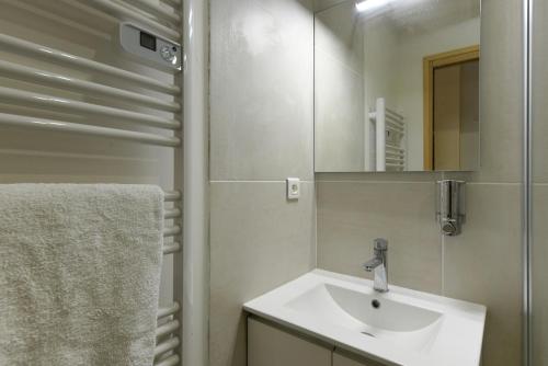 une salle de bain avec un lavabo et un miroir dans l'établissement Provençal Studio Netflix Appart-hotel-Provence, à La Fare-les-Oliviers