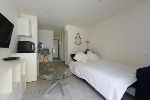 - une chambre avec un lit et une table en verre dans l'établissement Provençal Studio Netflix Appart-hotel-Provence, à La Fare-les-Oliviers