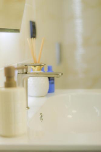 a kitchen counter with a sink with toothbrushes at Le camere del Cappello Verde in Ivrea