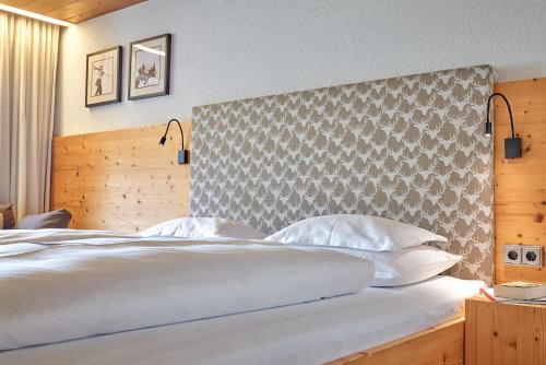 a bedroom with a large bed with white pillows at Aktiv & Spa Hotel Alpenrose in Schruns-Tschagguns