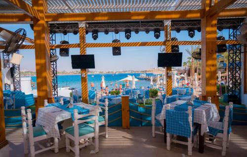 a restaurant on a cruise ship with blue tables and chairs at Marina Sharm Hotel in Sharm El Sheikh