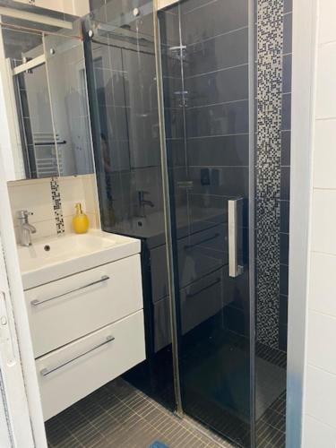 une salle de bain avec une douche en verre et un lavabo dans l'établissement Villa Bella, à Villeneuve-Loubet