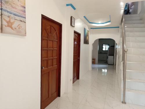 a hallway with two wooden doors and stairs at Drage Tourist Inn in Logon