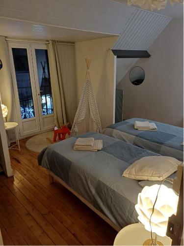 une chambre avec deux lits et une table avec une lampe dans l'établissement L'escapade Féroise, à Fère-en-Tardenois