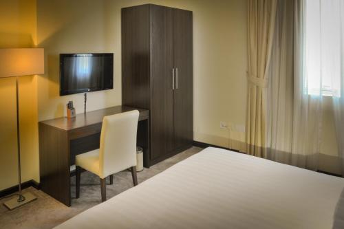 a hotel room with a bed and a television at Golden Ocean Hotel in Doha