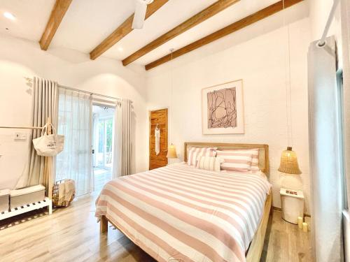 a bedroom with a bed and a large window at Jasmine Garden in Hoi An